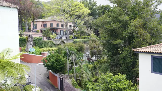 Ein rosafarbenes Quinta-Herrenhaus zwischen subtropischen Gärten oberhalb von Funchal, Madeira