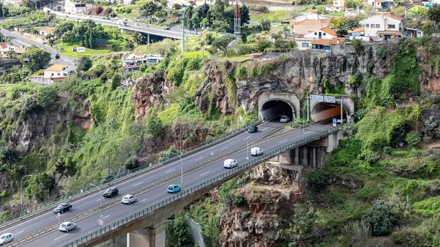 Cars on the ER101 expressway viaduct and rock tunnels above Funchal, Madeira
