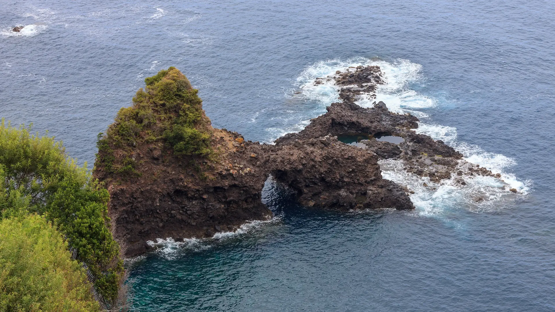 Wild Atlantic waves breaking around volcanic sea stacks at Seixal on Madeira's north coast