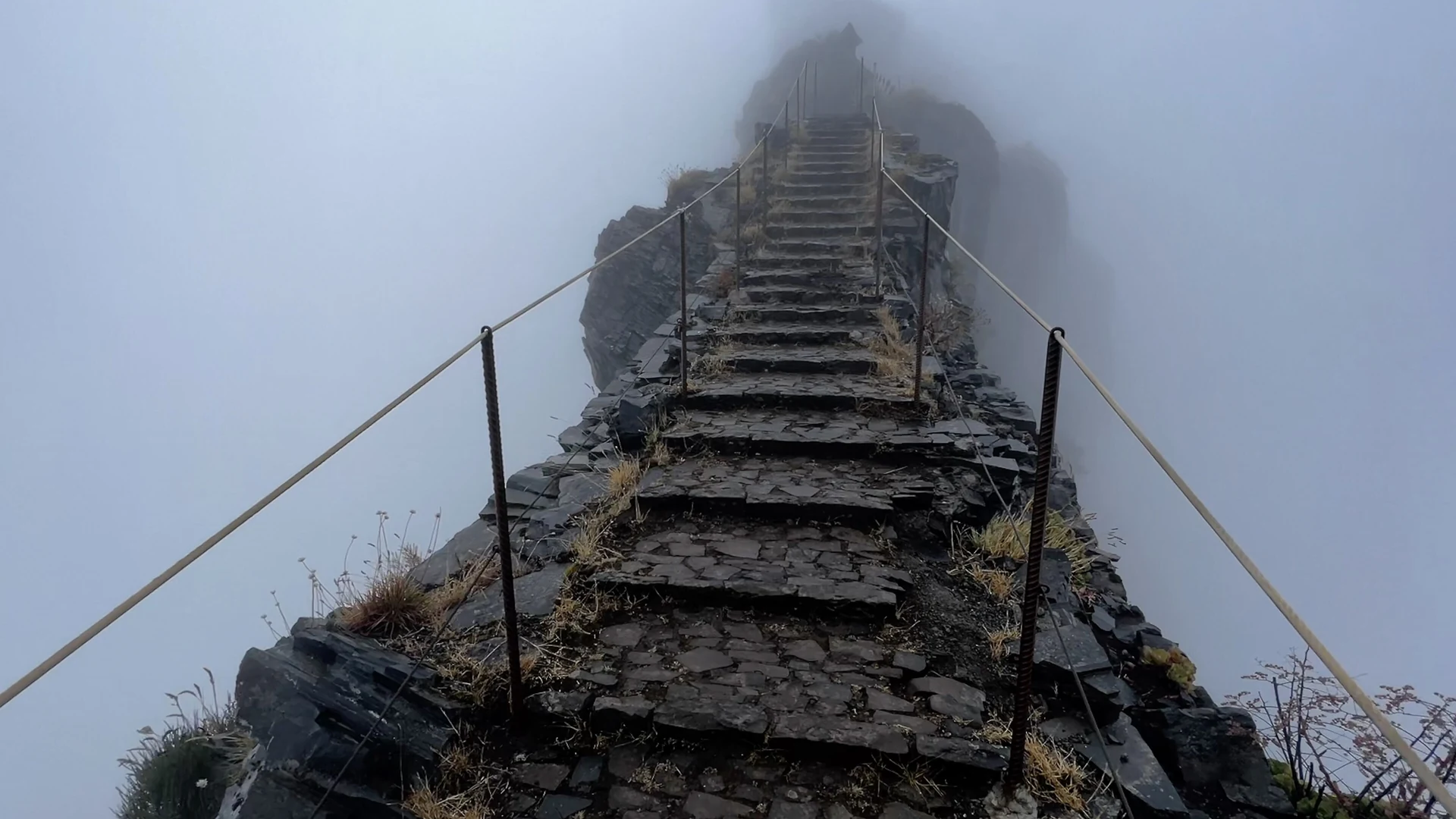 The PR1 ridge trail winding between volcanic peaks on the way to Pico Ruivo, Madeira